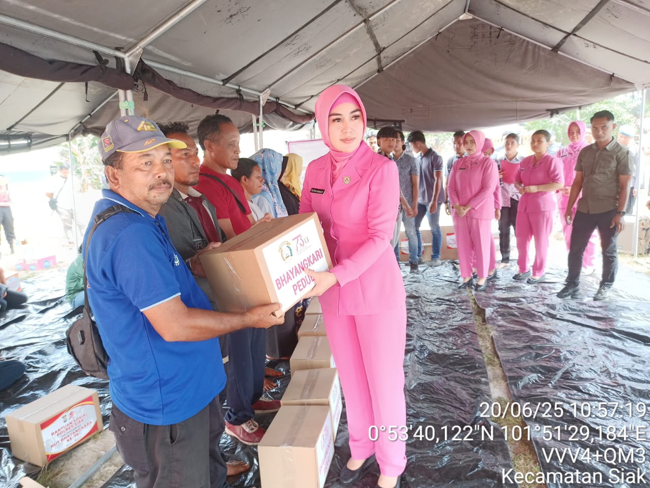 Ketua Bhayangkari Cabang Siak, Eka Priyanti Ariandy ketika menyerahkan bantuan kepada karyawan PT SSL di Desa Tumang. 