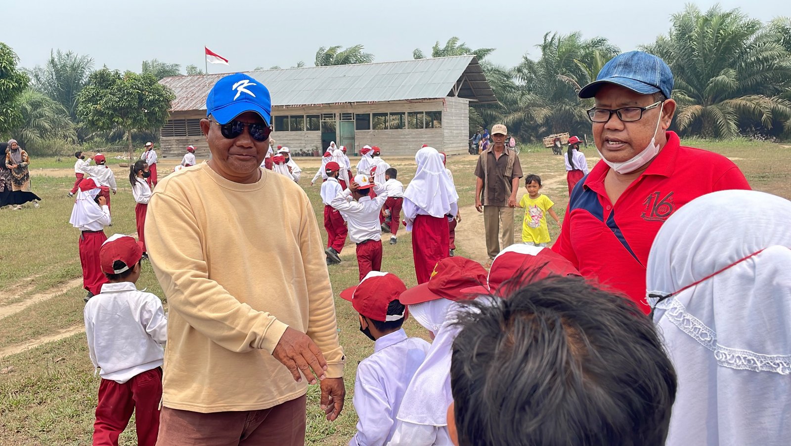 H Walirman gelar Datuk Mahudum bersama Masrijal gelar Datuk Marajo menyapa para murid SDN 008 Jarak Jauh Dusun Pematang Panjang.